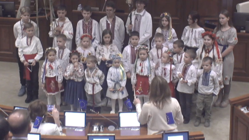 Un grup de copii refugiați din Ucraina a colindat la Parlament în română